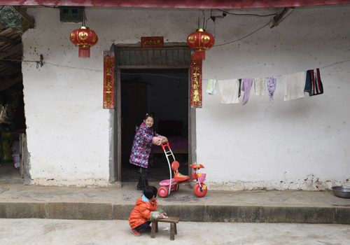 2月9日，水井村陈家小姐妹在院中玩耍新年礼物——小自行车。新华社记者 刘坤 摄