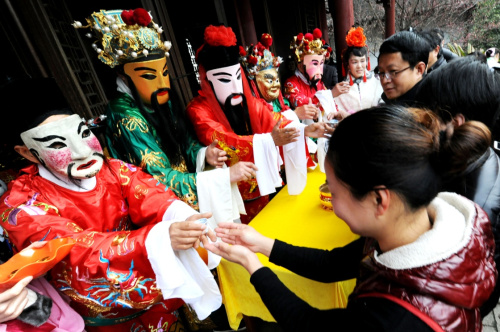 2月12日，苏州古山塘街上的商户接过“财神”所敬的“路头酒”。新华社发（王建中 摄）