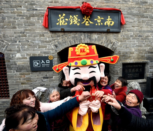 2月12日，在安徽省亳州南京巷钱庄景区，“财神”向游客发放红包。当日是农历正月初五，中国民间各地素有“接财神”的习俗。新华社发（刘勤利 摄）
