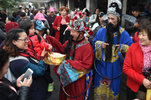 2月12日，“财神”送福队伍在西塘古镇为游客送去祝福，民间传说正月初五是财神的生日。新华社记者 黄宗治 摄