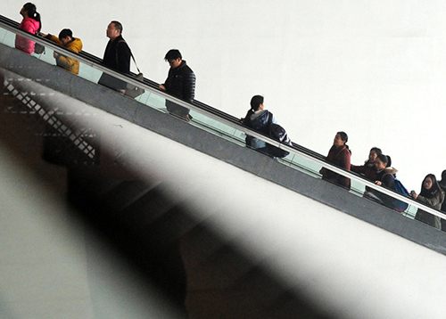 2月13日，准备出行的旅客乘坐电梯进入苏州火车站候车大厅。