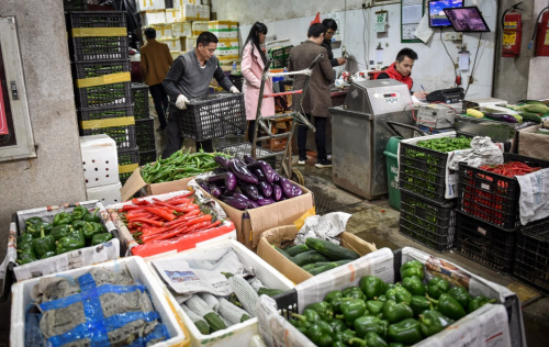 2月16日，工人在深圳海吉星批发市场搬运蔬菜。新华社记者 毛思倩 摄