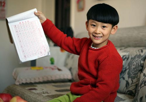 2015年2月11日，“光屁股小孩”高宇博在自家新房向记者展示他的作业。
