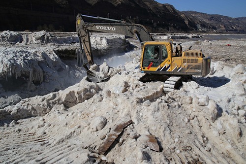 2月16日，山西吉县黄河壶口瀑布景区工作人员用挖掘机铲除堆冰。