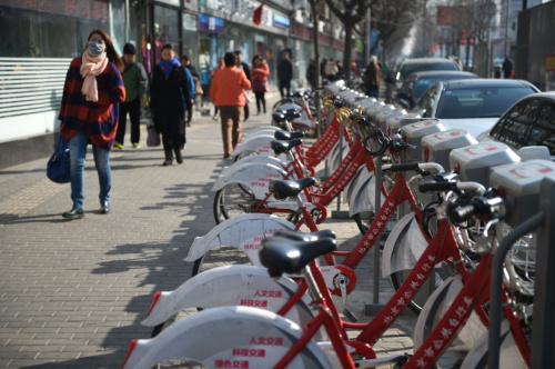 2月17日，行人走过位于北京市朝阳区一处公共自行车网点。新华社记者 鞠焕宗 摄