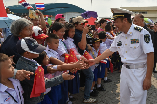 2月17日，中国海军第21批护航编队指挥员俞满江少将（右前）在泰国春武里府的兰乍邦港与前来迎接的泰国学生握手致意。新华社记者 李芒茫 摄