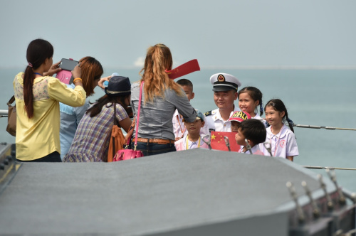 2月17日，在泰国春武里府的兰乍邦港，几名泰国小学生在中国海军第21批护航编队“三亚”号导弹护卫舰上与一名战士合影。中国海军第21批护航编队“柳州”号导弹护卫舰、“三亚”号导弹护卫舰和“青海湖”号综合补给舰17日停靠兰乍邦港码头，开始对泰国进行为期5天的友好访问。泰国海军举行隆重欢迎仪式。新华社记者 李芒茫 摄