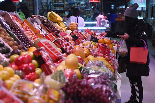 2月18日，市民在长春市一家农贸市场内挑选水果。