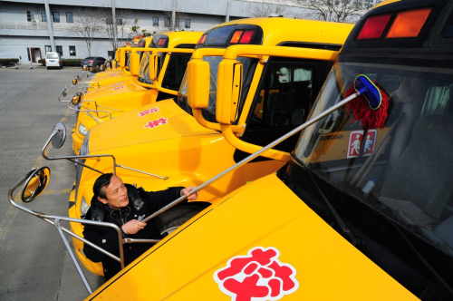 2月18日，江苏省太仓市校车驾驶员在擦拭校车前挡风玻璃。新华社发（计海新 摄）