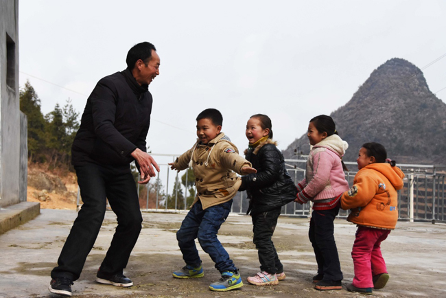 2月24日，陶朝雷老师与孩子们在课间做游戏。坐落在重庆市巫山县骡坪镇的苏家村小学，是一所位于海拔1000余米山区的“微小学”。学校里只有一位老师和四名学生。2月24日是学校开学的日子，现年52岁的陶朝雷老师带着一名三年级学生和三名学前班的孩子开始了新的学期。
