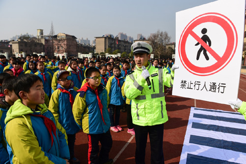 2月25日，学生们在交警的指导下识别交通标志。