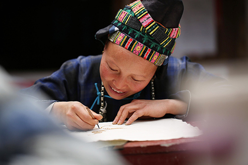 3月7日，在贵州省丹寨县扬武镇基加苗寨，一名苗族妇女在画蜡。