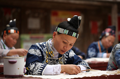 3月7日，在贵州省丹寨县扬武镇基加苗寨，苗族妇女在展示画蜡技艺。