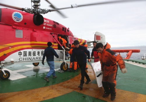 3月8日，中国考察队员在“雪龙”号后甲板停机平台卸运戴维斯站物资。新华社记者 朱基钗 摄