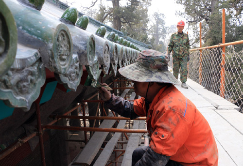 3月19日，在山东省邹城市孟庙景区，维修人员对亚圣殿木梁重新刷漆。