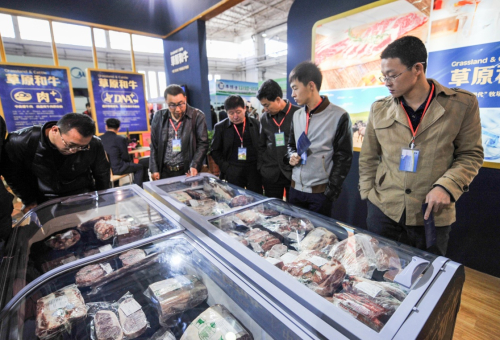 3月26日，参观者在博览会上查看展出商品。当日，第十届内蒙古国际乳业博览会在呼和浩特市国际会展中心开幕。本次博览会由内蒙古奶业协会主办，全国约200家企业参展，展会将持续至28日。新华社记者 连振 摄