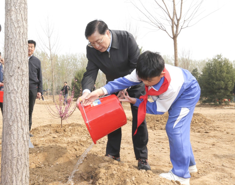 这是张德江同少先队员一起给刚栽下的树苗浇水。新华社记者 丁林 摄