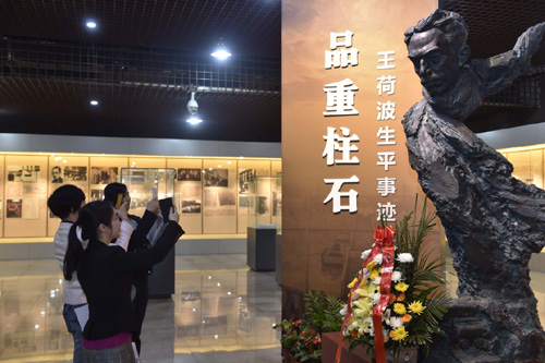 4月6日，观众在王荷波生平事迹展上拍摄王荷波同志雕塑。