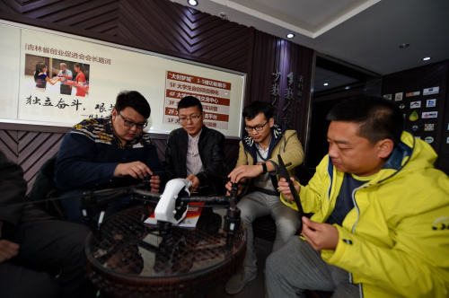 4月6日，孙品上（左二）、刘宸源（左一）与两位同事一起研究无人机改装方案。新华社记者 张楠 摄
