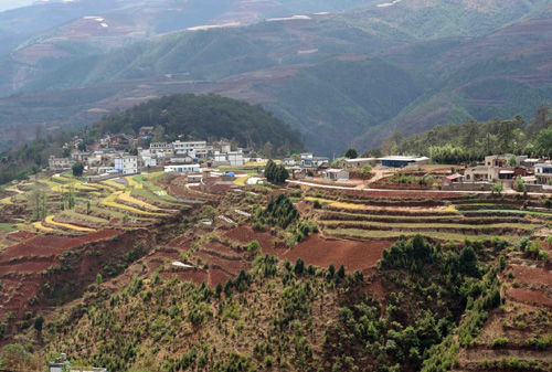 红土山坡上的寻甸县甸沙乡兴隆村景色（4月6日摄）。