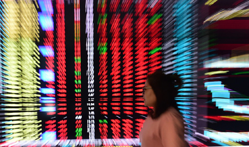   4月11日，一名沈阳股民在电子显示屏前关注股市行情。