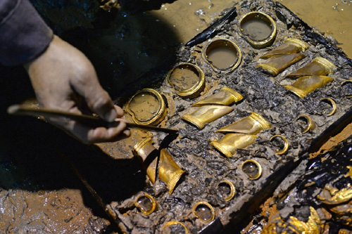 2015年11月17日，考古工作者在南昌西汉海昏侯墓主椁室西侧清理马蹄金。