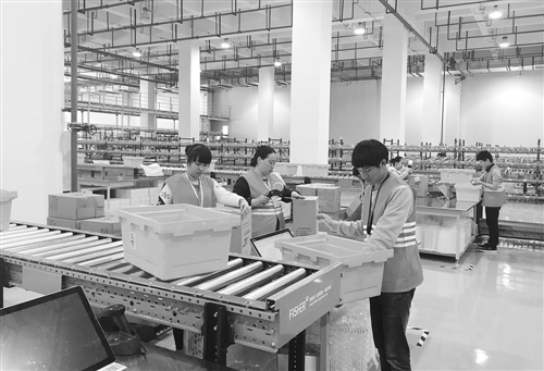 重庆市西部物流园内的跨境电商智能公共监管仓，是园区内的保税仓储处理区，面积约为5000平方米，向电商客户提供保税仓储、落地配送、清关等综合服务。4月13日，工作人员正在分拣打包和扫码收货。本报记者 李景摄