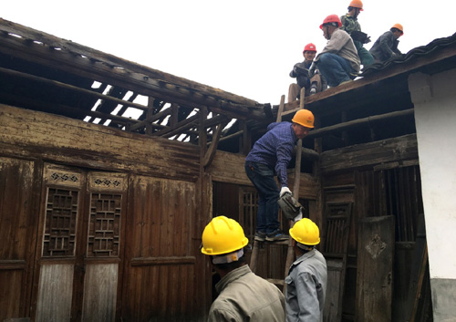 4月14日，在浙江丽水市松阳县山下阳村，工作人员取下老屋屋顶瓦片，准备进行修缮。