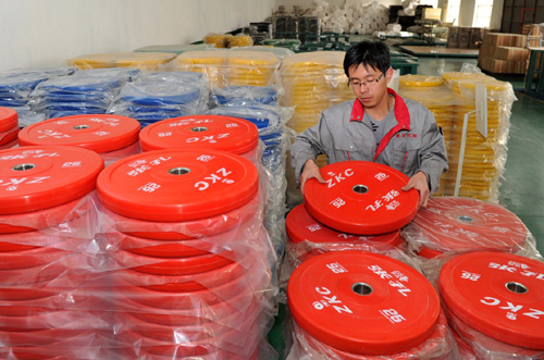 4月14日，河北省泊头市张孔杠铃公司工人在整理杠铃片。