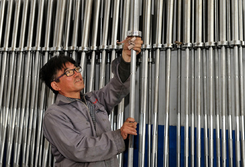 4月14日，河北省泊头市张孔杠铃公司工人在擦拭刚刚下线的成品杠铃杆。