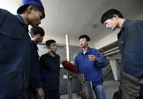 焊接技能专家魏力钧（右二）在指导太谷职业中学的学生进行焊接操作（5月12日摄）。新华社记者 燕雁 摄