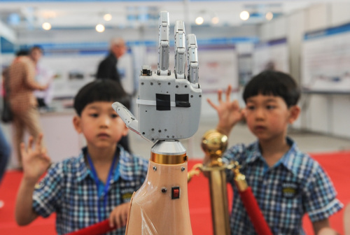 5月22日,两名小朋友在参观博览会上展出的智能机器人手臂。新华社记者 王松 摄 5月22日,两名小朋友在参观博览会上展出的智能机器人手臂。新华社记者 王松 摄