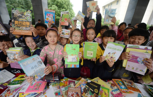 5月29日，扬州市梅岭小学学生展示在“跳蚤书市”中挑选的图书。“六一”儿童节即将来临，江苏省扬州市梅岭小学西区校举办以“分享阅读 ，快乐六一”为主题的“跳蚤书市”，学生们交换图书，分享阅读感悟。新华社发（孟德龙 摄）