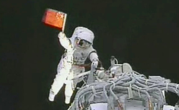 2008年9月27日，执行神舟七号载人航天飞行出舱活动任务的航天员翟志刚出舱后挥动中国国旗（摄于北京航天飞行控制中心大屏幕）。新华社发