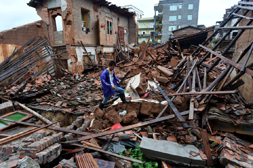 7月9日，莆田市新度镇凌厝村受灾村民在自己倒塌的房屋上清理杂物。