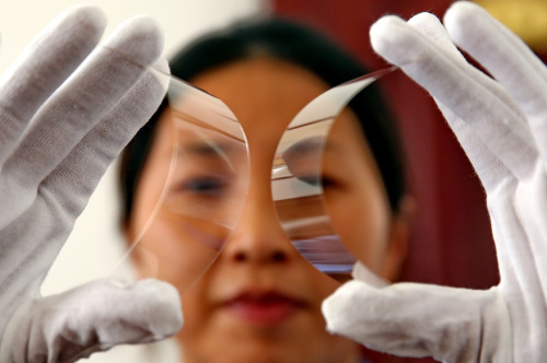 秦皇岛星箭特种玻璃有限公司的工人在展示高强度抗辐照玻璃盖片。