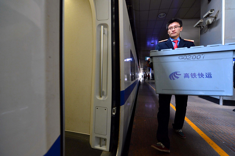 11月10月，中铁快运济南分公司济南站营业部工作人员将货物搬到D6005次动车上。