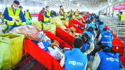 12日下午，在圆通快递北京分拨处理中心，工人正在将刚送来的一袋袋包裹拆包分拣。