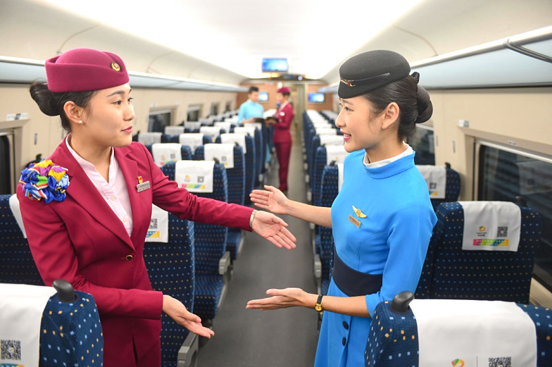 12月1日,南昌铁路局福州客运段“高姐”陈珑(左)与厦门航空“空姐”乐杨威交流空铁服务差异。