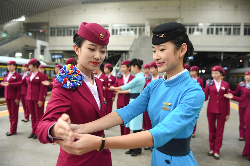 12月1日，厦门航空的“空姐”（前右）为南昌铁路局福州客运段“高姐”讲解服务手势。