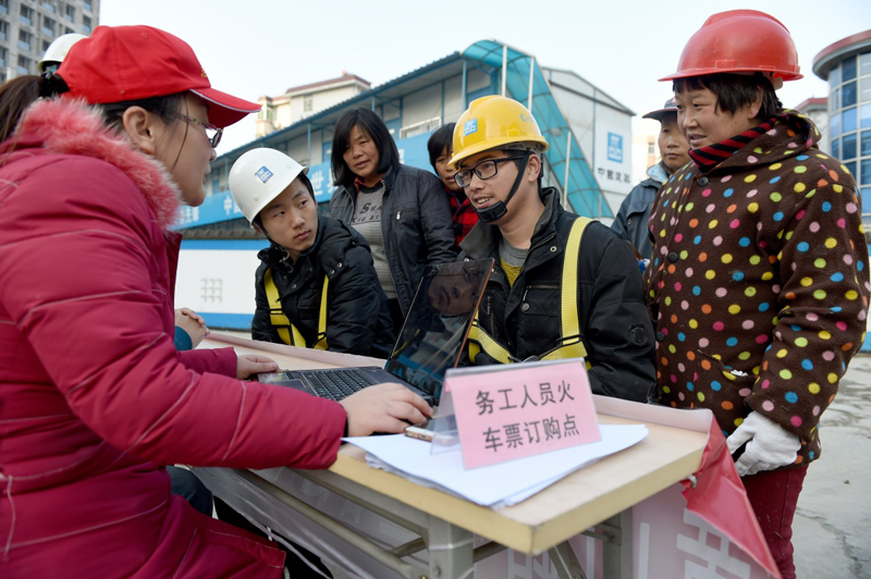 12月15日，安徽合肥黄山路社区的志愿者在一处工地帮助农民工购买春运火车票。当日，2017年春运火车票在网络、电话平台率先开售。火车站售票窗口开售则从17日开始。2017年铁路春运从1月13日起至2月21日止，全国铁路预计发送旅客3.56亿人次，同比增加3156万人次。网购火车票预售期从以往的60天调整为30天，车站、代售点、自动售票机由58天调整为28天。