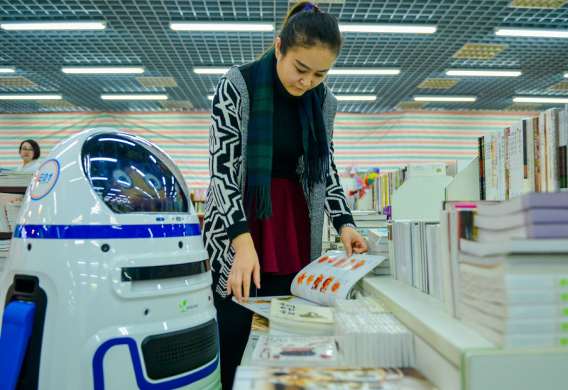 12月19日，机器人导购员“小胖”在书店内为读者提供咨询服务。