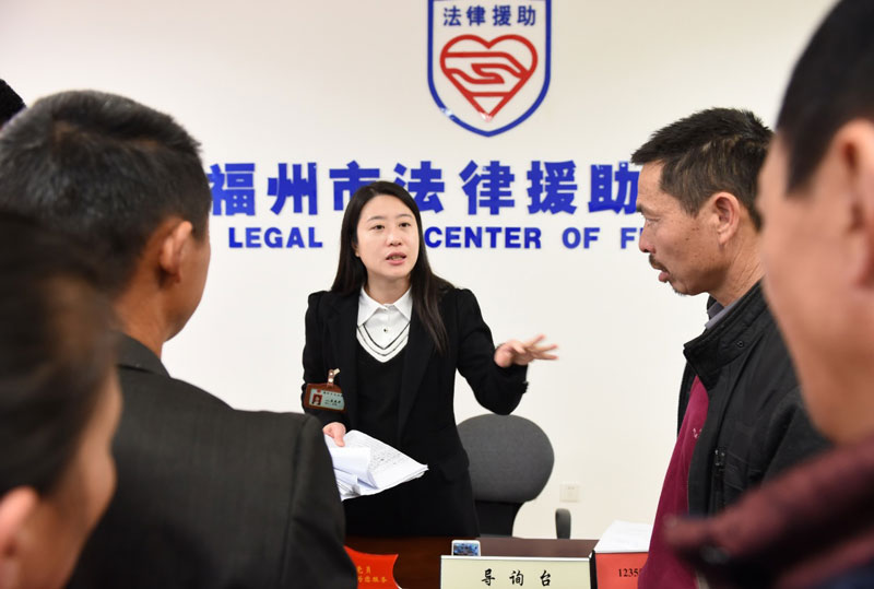  2月19日，法律援助工作者庄晶萍（中）在福州市法律援助中心为外来务工者提供讨薪等方面的法律援助。