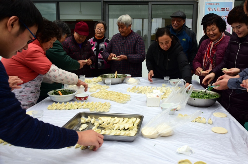 12月21日，江苏省镇江市润州区七里甸街道曙光村开展“冬至包饺子，温暖老人心”活动，工作人员与空巢老人一起包饺子。