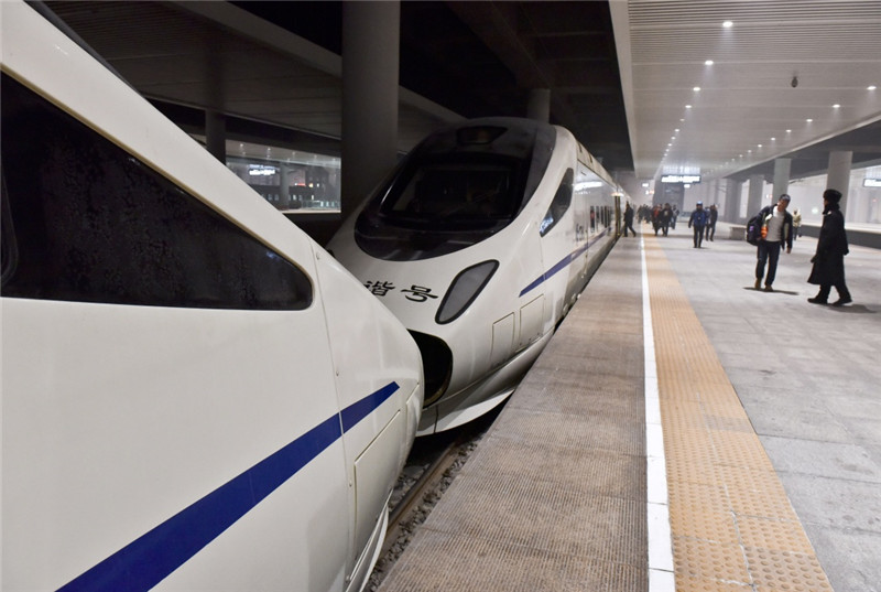 1月5日,乘客在乌鲁木齐站准备登上两列重联的D8802次动车组列车。