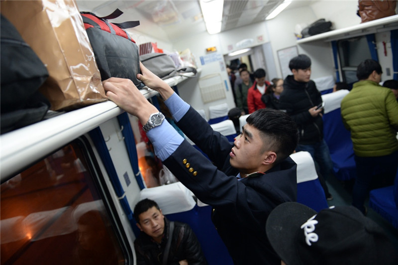 1月7日，列车乘务员在K4099次新增列车上整理旅客行李。