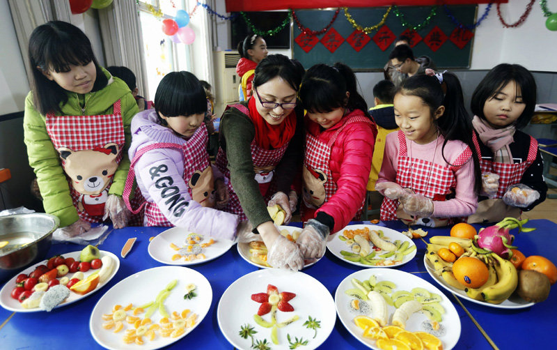 1月19日，孩子们在深州市文化馆培训基地老师的指导下做水果拼盘。寒假来临，河北省深州市组织志愿者开办寒假快乐小课堂活动，为放寒假的孩子们开展书法绘画、手工制作、攀岩、阅读课外书等活动，让孩子们度过一个充实有意义的假期。新华社记者 王晓 摄