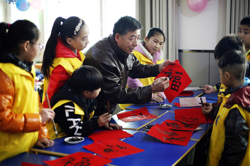 1月19日，孩子们在深州市文化馆培训基地老师的指导下学习书法。寒假来临，河北省深州市组织志愿者开办寒假快乐小课堂活动，为放寒假的孩子们开展书法绘画、手工制作、攀岩、阅读课外书等活动，让孩子们度过一个充实有意义的假期。新华社记者 王晓 摄