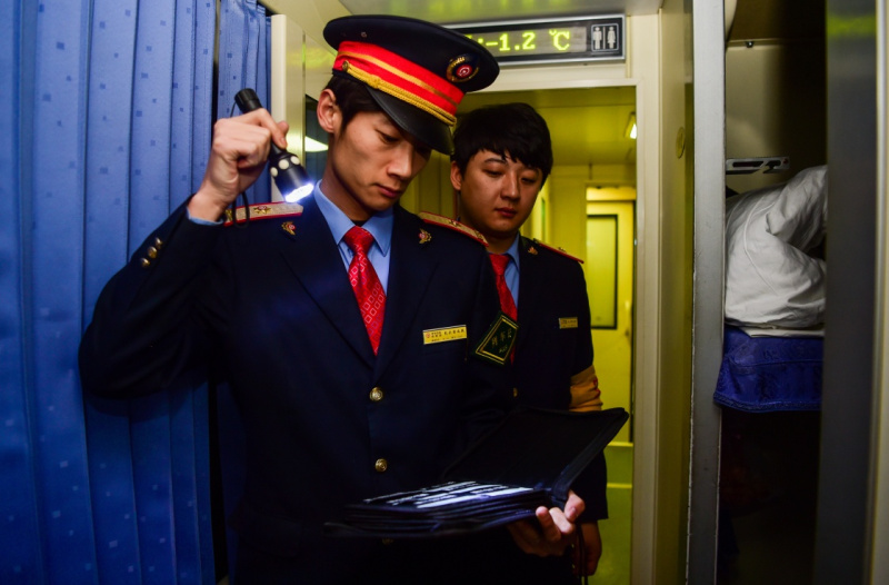 1月24日,z184列车的列车长刘一鸣(左)在查验车票.