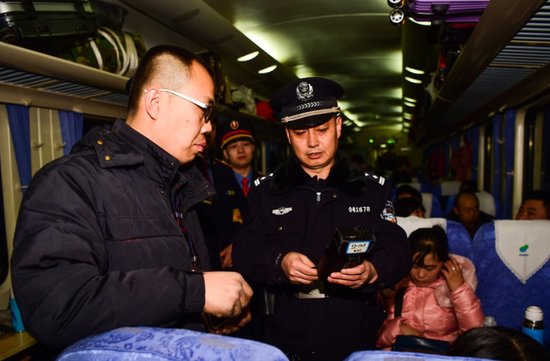 1月24日,z184列车的乘警长郭元平(右)在查验旅客身份证.
